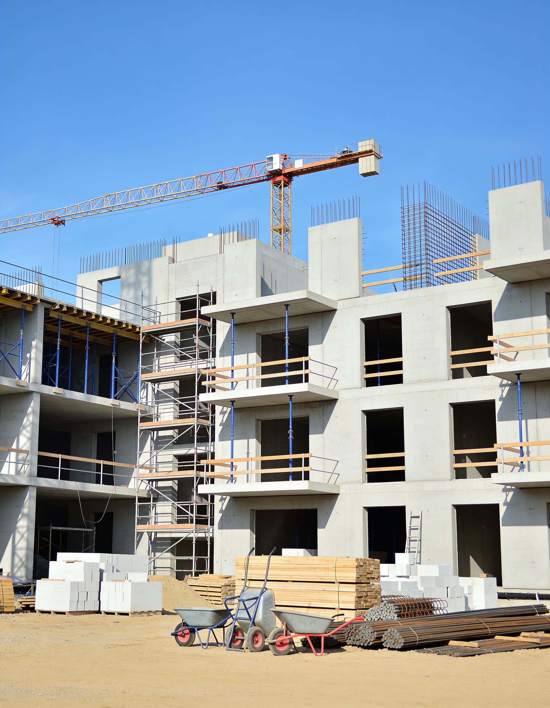 Multi-story structure under construction with crane overhead